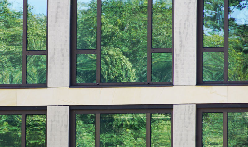DOMBERT Rechtsanwälte - Hausfassade Fensterfront mit Baumspiegelung, Standort Campus Jungfernsee