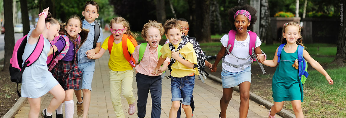 Das Bild zeigt Schulkinder die fröhlich gemeinsam lachen und auf dem Weg zur Schule sind, das Bild dient als Beitragsbild zum Blogbeitrag 'Grundrecht auf Bildung' von Dombert Rechtsanwälte Franziska Wilke